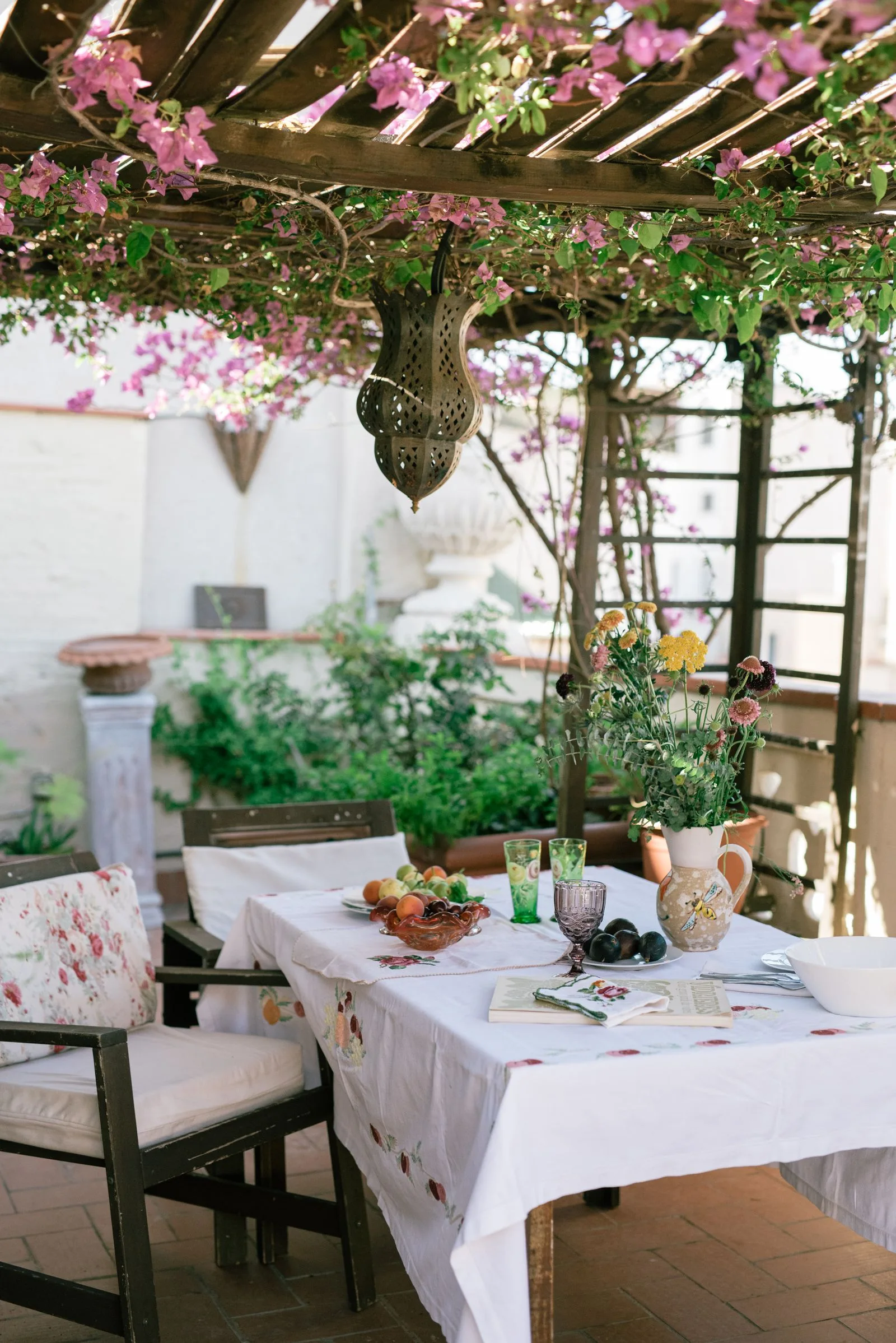 An outdoor table beneath flowering vines